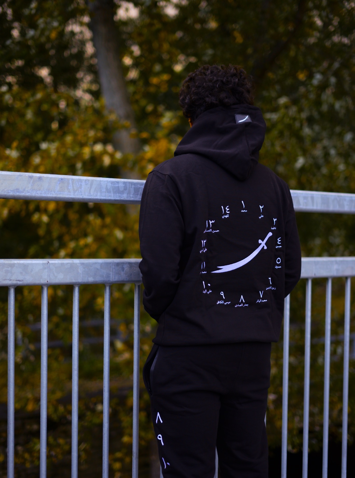 The 14 matching hoodie and sweatpants seen from behind, displaying the original sword artwork and Arabic numerals